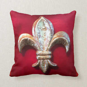 Coussin Fleur-De-lis d'or contre la terre rouge foncé