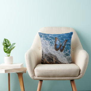 Coussin Morpho commun papillon volant au-dessus d'un roche