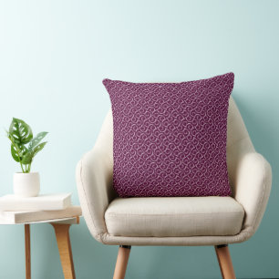 Coussin Ornement blanc sur fond bordeaux.