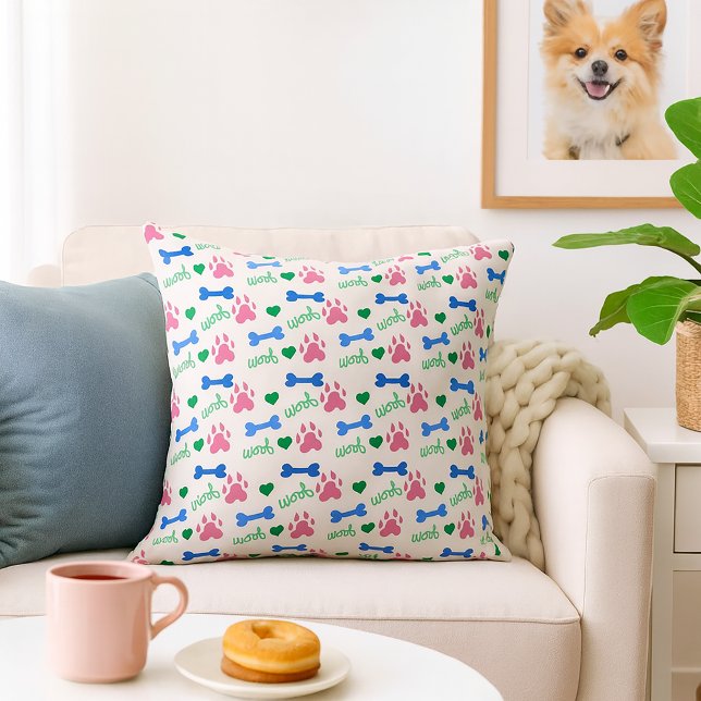 Coussin Os de chien Woof Rose Bleu Vert Motif (A throw pillow with a pattern of pink dog paws, blue bones and green woofs.)