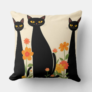 Coussin Trois chats noirs parmi des fleurs brillantes