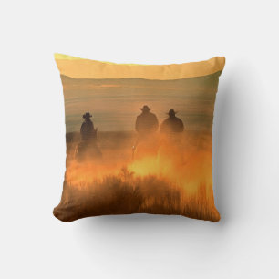 Coussin Trois cow-boys galopant sur un arrière - plan de m