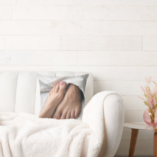 Coussin Un homme et un pied de femme sur un drap blanc