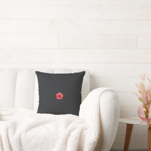 Coussin une fleur rouge avec un centre noir sur un dossier