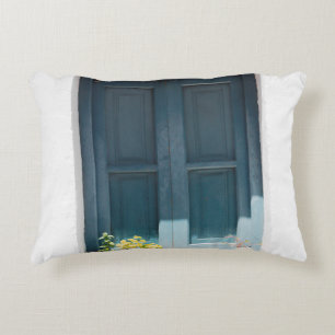 COUSSINS DÉCORATIFS PORTE EN BOIS BLEU SUR MUR BLANC EN BÉTON