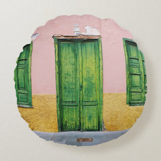 COUSSINS RONDS PORTE EN BOIS VERT SUR MUR EN BÉTON BLANC