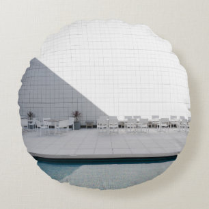 COUSSINS RONDS TABLE DE PATIO BLANCHE AVEC CHAISES EN JOURNÉE