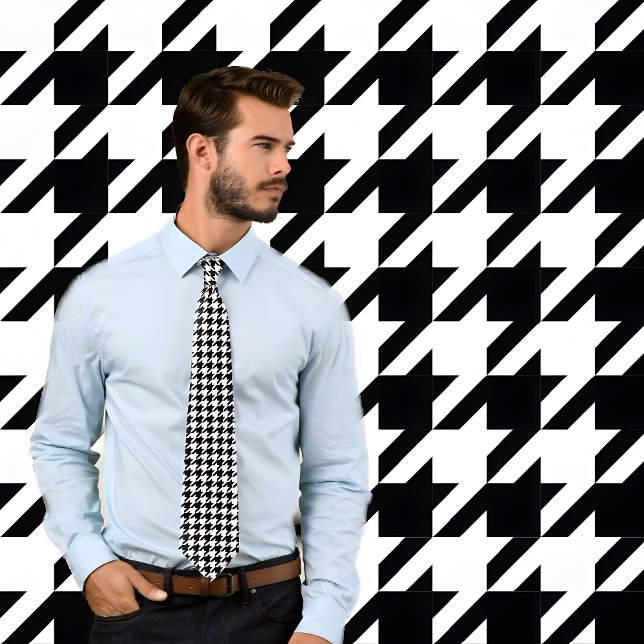 Cravate classique de contrôle de la jambe noire et (Man wearing black and white houndstooth pattern necktie. He stands against wall with same pattern.)