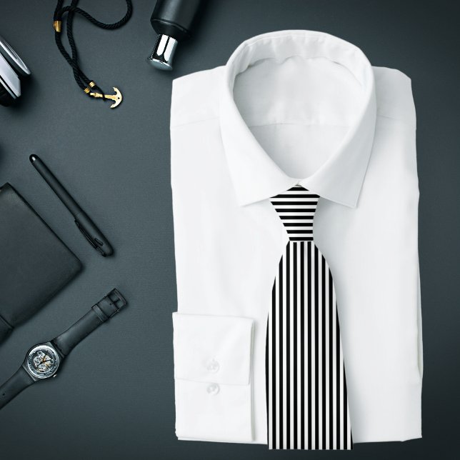Cravate rayures verticales fines noir et blanc (A black and white vertical striped tie is featured on an assemblage of men's accessories.)
