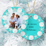 Décoration En Céramique Christmas Beach Wreath Sand Dollar Starfish<br><div class="desc">A wreath of white sand dollars, starfish, and aqua glitter coral frame the family photo on the front of this beach themed ornament, with an aqua blue background, with family name, year, and Merry Christmas on the back. Please contact me through Zazzle Chat if you need matching products, design tweaks...</div>