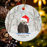 Décoration En Céramique Mignonne Otter avec Santa Hat Nom de l'enfant<br><div class="desc">Un ornement de Noël intemporel et mignon avec une adorable louette avec un casquette de Père Noël rouge vif. L'arrière - plan au thème de l'aquarelle présente une subtile chute de neige hivernale de pastels muets au milieu de la forêt pleine d'arbres. Deux coeurs rouges accompagnent la loutre. La typographie...</div>