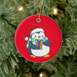 Décoration En Céramique Penguin dans un casquette de Noël avec un cadeau