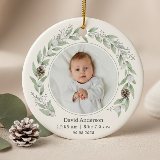 Décoration En Céramique Photo Enfant Holly Wreath Noël 2025 (A round ornament featuring a central baby photo circled by a delicate watercolor greenery wreath.)