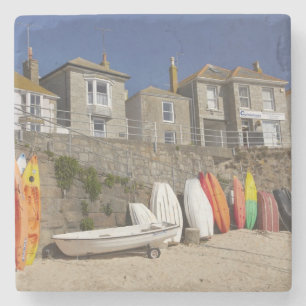 Dessous-de-verre En Pierre Kayaks et canots empilés contre la digue à