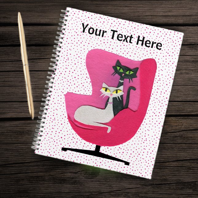 Deux chats assis dans un fauteuil rose milieu du s (Pretty cats sitting in mid century pink chair yellow green eyes pink polka dotted planner.)
