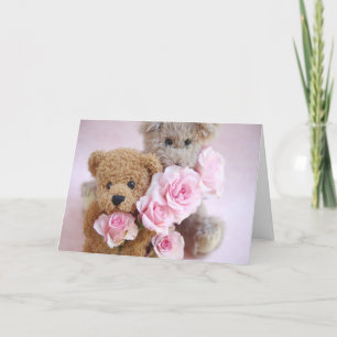 deux nounours tenant une carte de voeux rose