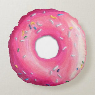 Donut rose avec des arroses autour de coussin