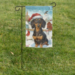 Drapeau De Jardin Dachshund Winter Wonderland Christmas Joy<br><div class="desc">Ce design festif reflète l'esprit joyeux de la période des fêtes, avec un adorable petit portant un chapeau de Père Noël. Le chien est niché dans un pays des merveilles hivernales, avec un bonhomme de neige, un sapin de Noël décoré et des cadeaux joliment emballés. Les flocons de neige tombent...</div>