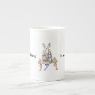 En Porcelaine Dessin d'Aardvark assis et buvant d'une tasse