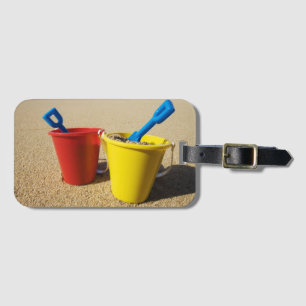 Étiquette À Bagage Pelles et seaux sur la plage sablonneuse