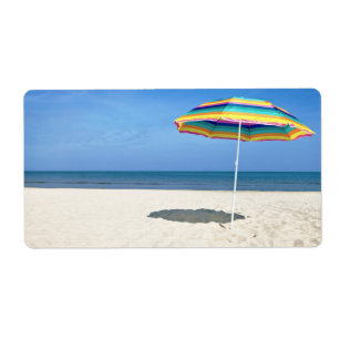 Étiquette Parapluie de plage coloré sur la plage sablonneuse