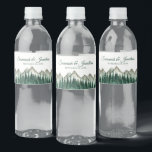 Étiquette Pour Bouteilles D'eau Rustic Watercolor Mountains & Pine Trees Mariage<br><div class="desc">Ces étiquettes de bouteilles d'eau rendront votre célébration mariage d'autant plus spéciale. Elles présentent un design rustique mais élégant avec un paysage aquarelle de sommets alpins avec une forêt de pins verts au premier plan. Il y a des lettres de script pour les noms du couple mariage et un endroit...</div>