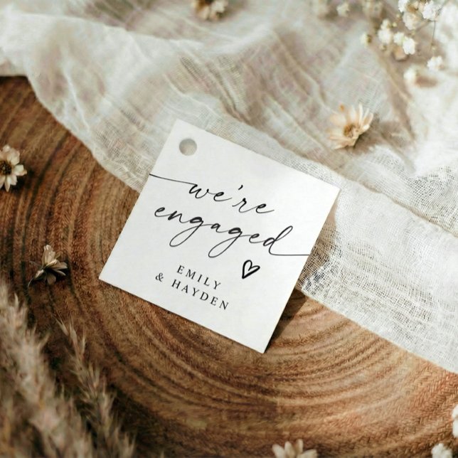 Étiquettes Cadeau Fête de fiançailles moderne simple écriture manusc (Modern black and white we're engaged favor tags with elegant handwriting and heart)
