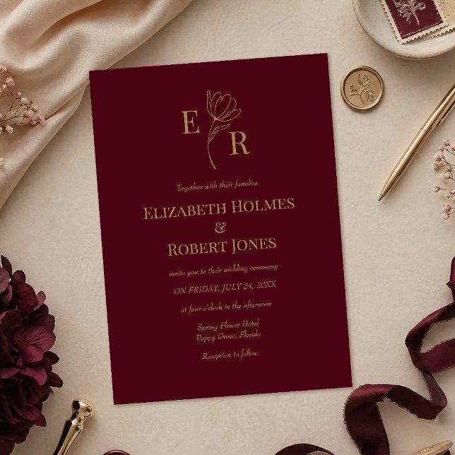 Faire-part de mariage à monogramme floral moderne  (Modern Burgundy Floral Monogram Wedding Invitation on a table with burgundy and gold wedding decor)