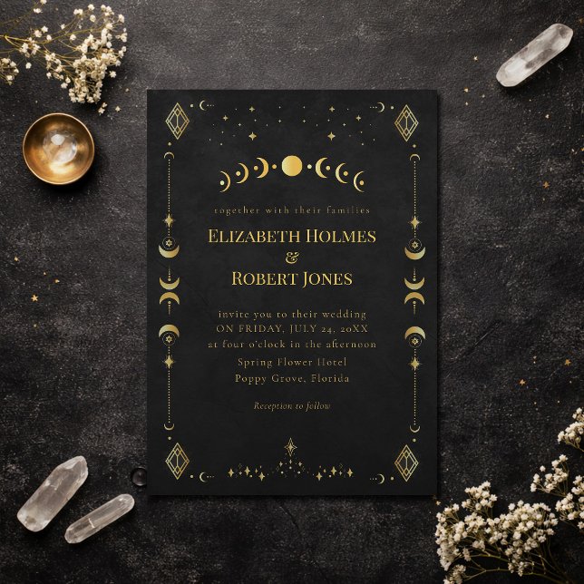 Faire-part de mariage Céleste Gothique Noir et Or (Celestial Gothic Black and Gold Wedding Invitation on a dark elegant table with dry flowers)