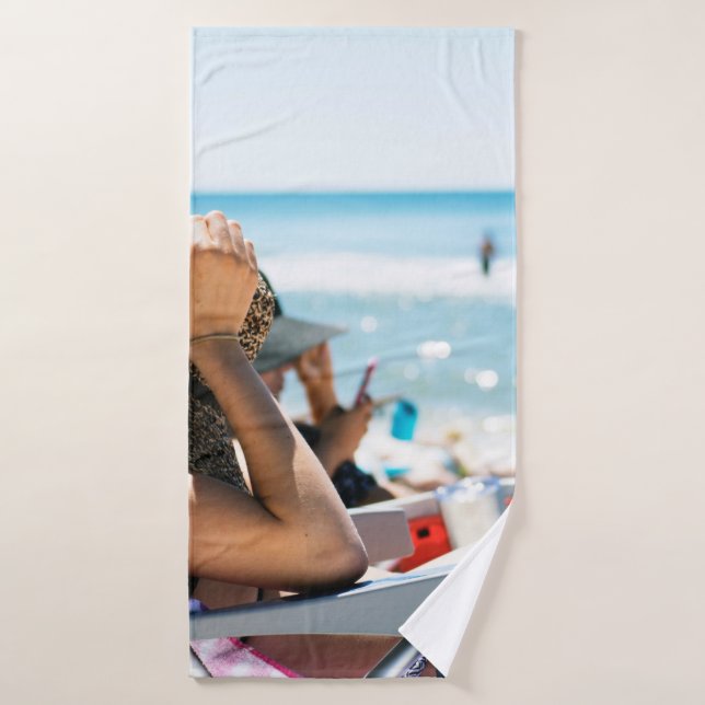 Femme allongée sur une chaise longue qui couvre so (Serviette de bain)