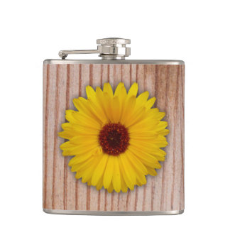 Flasques Marigold de tournesol sur des planches en bois rus