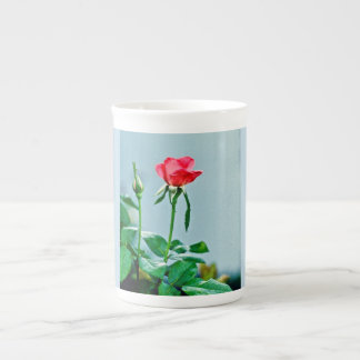 Fleur et bourgeon roses sur la tasse de porcelaine