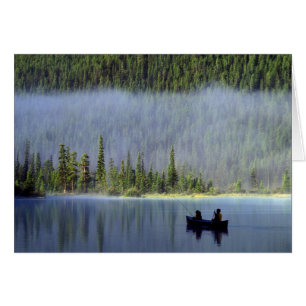 Garçons pêchant depuis un canoë avec de la brume d