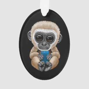 Gibbon mignon de bébé tenant un noir de téléph