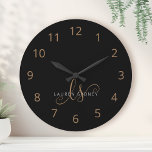 Grande Horloge Ronde Script féminin Black Gold moderne Monogramme<br><div class="desc">Script Feminine Noir Moderne Monogrammé Grande Horloge. Personnalisez facilement cette grande horloge moderne et élégante avec votre monogramme et votre nom personnalisés.</div>