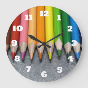 Grande Horloge Ronde Une rangée de crayons colorés.