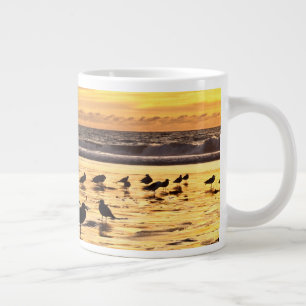 Grande Tasse Mouettes sur la plage au coucher du soleil