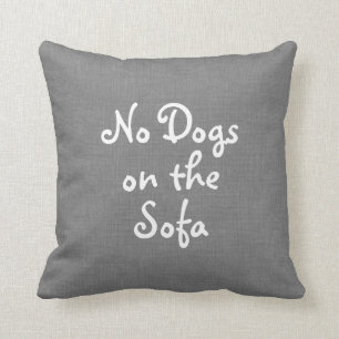 Gris aucuns chiens sur le coussin de sofa