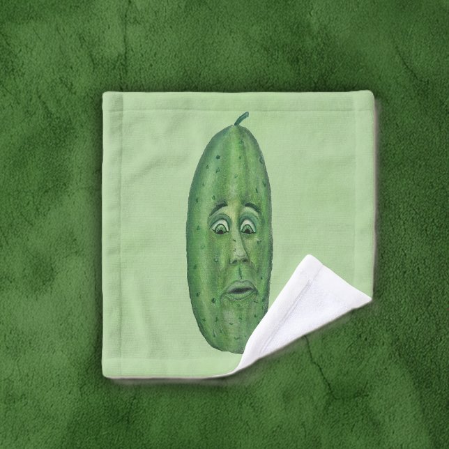 Gros Pickle Vert Avec Visage Surpris sur Fond Vert (Big green pickle with a surprised looking silly face on light green bath washcloth.)
