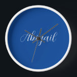 Horloge Calligraphie Elégant Bleu Blanc Plaine Nom simple<br><div class="desc">Vous recherchez une belle calligraphie avec une écriture esthétique ? Ce design simple et attrayant est fait pour vous. Ce produit impressionne immédiatement ceux qui le voient. Le design raffiné et de bon goût reflétera immédiatement la qualité de votre relation et de votre famille.</div>