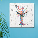 Horloge Carrée Arbre arc-en-ciel étoile d'or<br><div class="desc">Cette horloge fantaisiste est décorée d'un imprimé d'un design Arbre de Vie dans les couleurs arc-en-ciel et les étoiles d'or. L'arbre a été à l'origine fabriqué en mosaïque à l'aide de minuscules fragments de verre aux couleurs vives. Parce que nous créons notre propre oeuvre, vous ne trouverez pas cette image...</div>