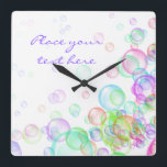 Horloge Carrée Bulles de savon<br><div class="desc">Si vous avez une affaire liée aux enfants, ou si vous faites du savon parfumé, ou si vous aimez simplement les bulles de savon, c'est le design pour vous. C'est une illustration joyeuse et dynamique de bulles de savon avec toutes les couleurs de l'arc-en-ciel flottant dans l'air. Choisissez ces bulles...</div>