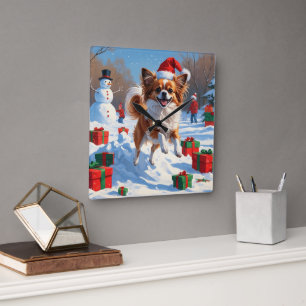 Horloge Carrée Chien Papillon courant dans la neige avec un chape