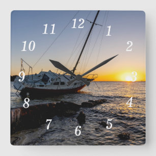 Horloge Carrée Coucher de soleil sur un voilier et une jetée à Gu