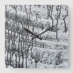 Horloge Carrée goutte de peinture noire sur béton