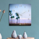 Horloge Carrée Hawaii Palm Tree Purple Paysage Photo Style<br><div class="desc">Appréciez la beauté de la nature chaque fois que vous regardez l'heure sur cette photo bleu et violet doucement éclairé horloge murale de palmiers soufflant dans la brise hawaïenne sur un fond de montagne. Vous avez le choix entre un visage rond ou carré. Fait un grand cadeau de ménage! Vous...</div>