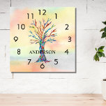 Horloge Carrée nom Monogram Rainbow Tree Square Wall Clock<br><div class="desc">Cette horloge murale colorée est décorée d'un arbre en mosaïque aux couleurs de l'arc-en-ciel sur un arrière - plan d'aquarelle. Facilement personnalisable avec votre nom ou monogramme. Parce que nous créons notre propre oeuvre,  vous ne trouverez pas cette image exacte d'autres designers. Mosaïque originale et aquarelle © Michele Davies.</div>