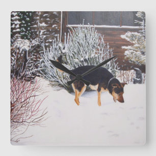 Horloge Carrée Winter snow scene with cute black and tan dog