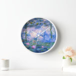 Horloge Nappes D'Eau<br><div class="desc">Water Lilies est une série de plus de 200 peintures à l'huile réalisées par l'impressionniste Claude Monet français. Cette belle horloge murale présente l'un de ces tableaux colorés. Il dispose d'un étang avec des fleurs de nénuphars dans les tons bleu et rose.</div>