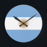 Horloge Ronde argentine<br><div class="desc">Drapeau de l'Argentine. Le drapeau national de l'Argentine est un tribande, composé de trois bandes horizontales tout aussi larges de couleur bleu clair, blanc et bleu clair. Le drapeau intégral arborant le soleil s'appelle le drapeau officiel du cérémonial (espagnol : Bandera Oficial de Ceremonia). Le drapeau sans soleil est considéré...</div>